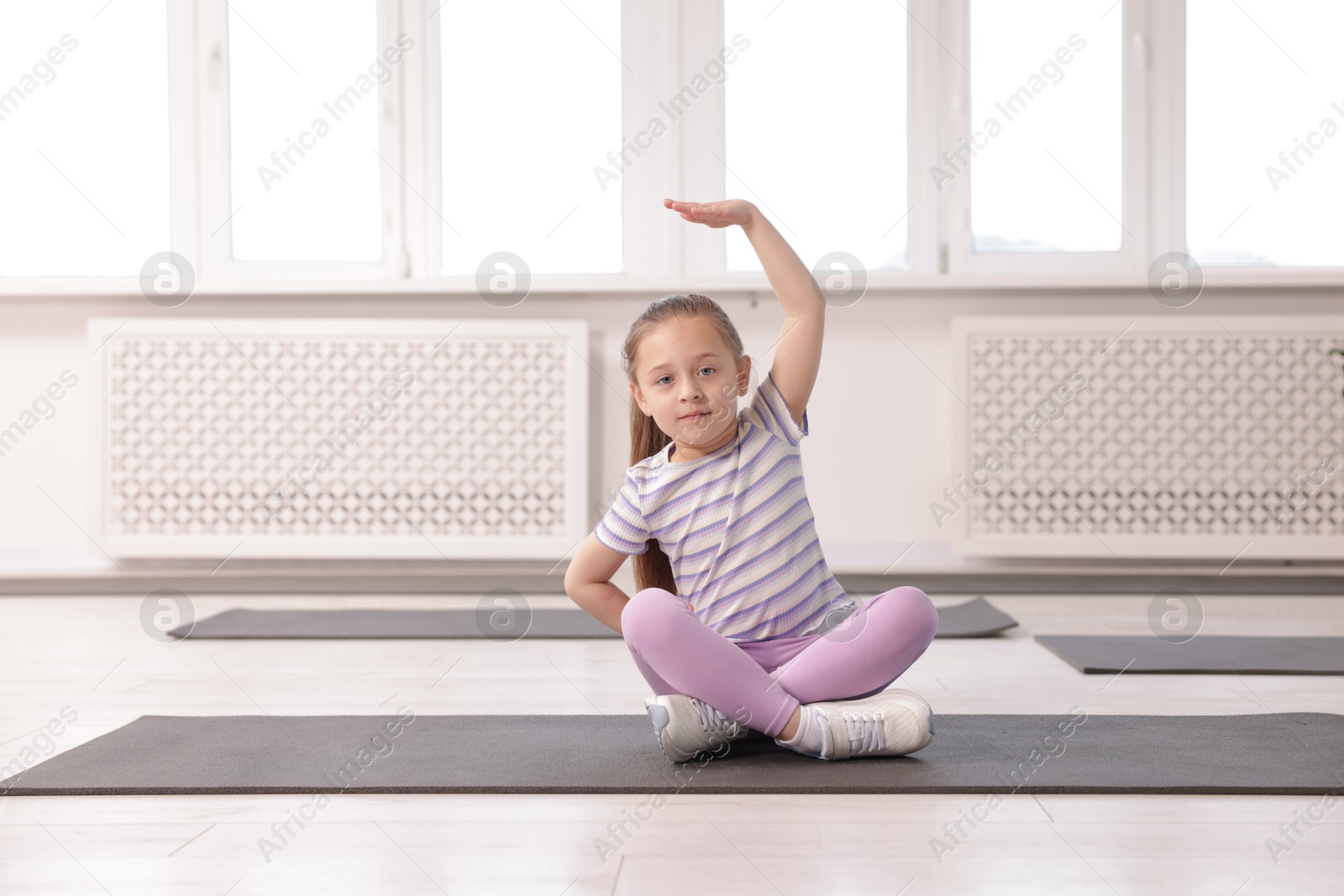 Cute girl practicing yoga on mat indoors Photo of Cute girl practicing yoga on mat indoors