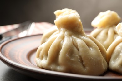 Photo of Delicious cooked khinkali served on table, closeup