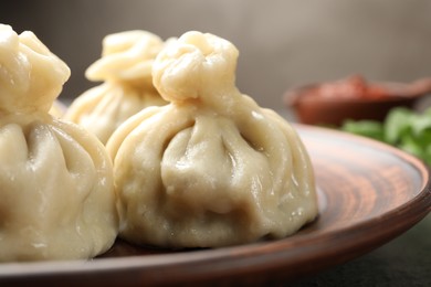 Photo of Delicious cooked khinkali served on table, closeup