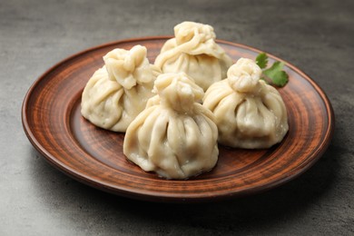 Photo of Delicious khinkali served on grey table, closeup