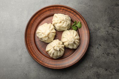 Photo of Delicious khinkali served on grey table, top view