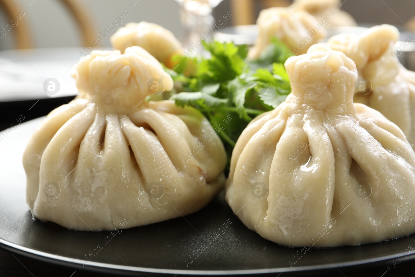 Delicious khinkali served with cilantro on table, closeup Photo of Delicious khinkali served with cilantro on table, closeup