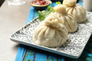 Photo of Delicious cooked khinkali served on grey table, closeup