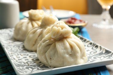 Photo of Delicious cooked khinkali served on grey table, closeup