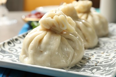 Photo of Delicious cooked khinkali served on table, closeup