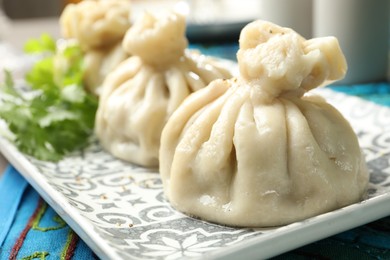 Photo of Delicious cooked khinkali served on table, closeup