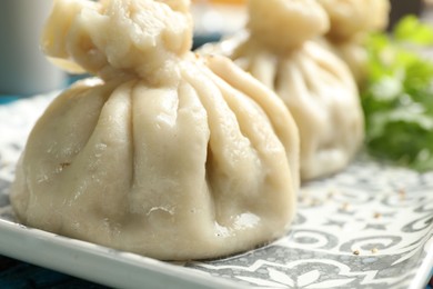 Photo of Delicious cooked khinkali served on table, closeup