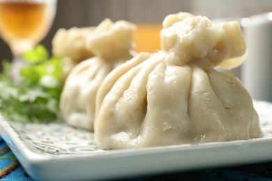 Photo of Delicious cooked khinkali served on table, closeup