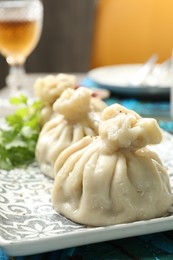 Photo of Delicious cooked khinkali served on table, closeup