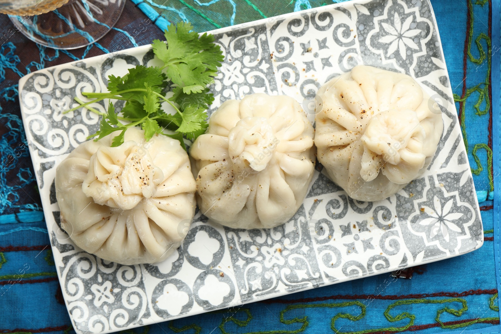 Delicious khinkali served with cilantro on table, top view Photo of Delicious khinkali served with cilantro on table, top view