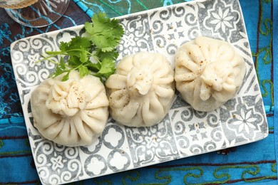 Photo of Delicious khinkali served with cilantro on table, top view