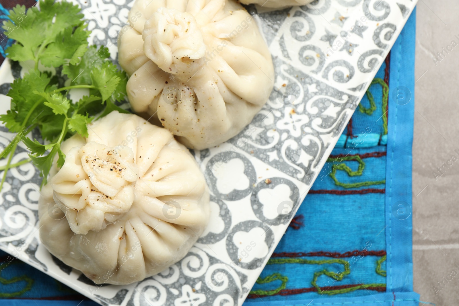 Delicious khinkali served with cilantro on grey table, top view Photo of Delicious khinkali served with cilantro on grey table, top view