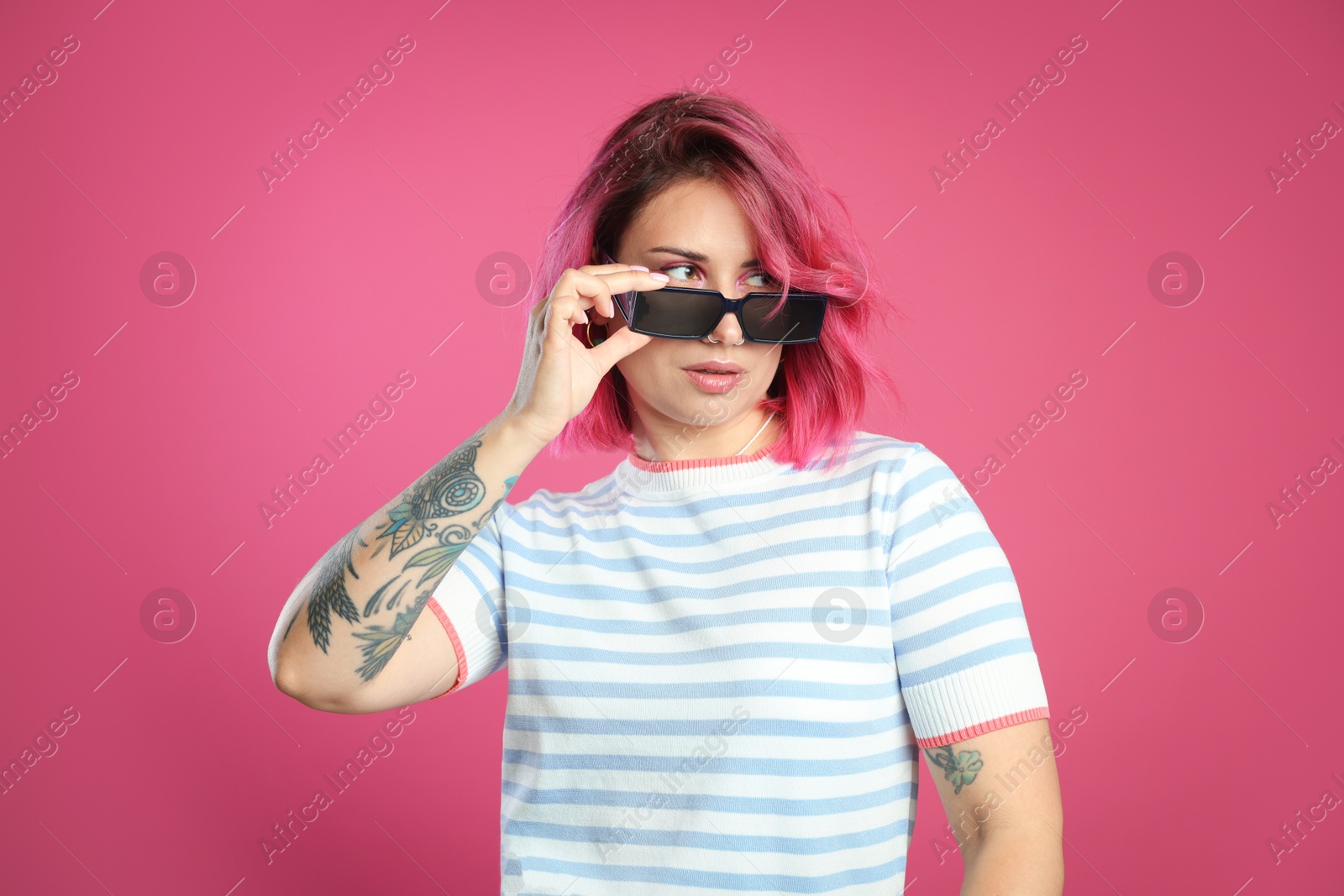 Beautiful woman with bright dyed hair in sunglasses on pink background Photo of Beautiful woman with bright dyed hair in sunglasses on pink background