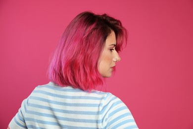 Photo of Beautiful woman with bright dyed hair on pink background