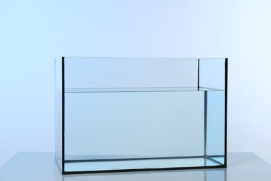 Photo of Glass aquarium with water on light background