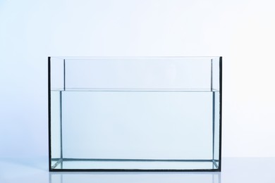 Photo of Glass aquarium with water on white background