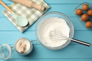 Photo of Whisk, whipped cream in bowl, eggs and flour on light blue wooden table, flat lay