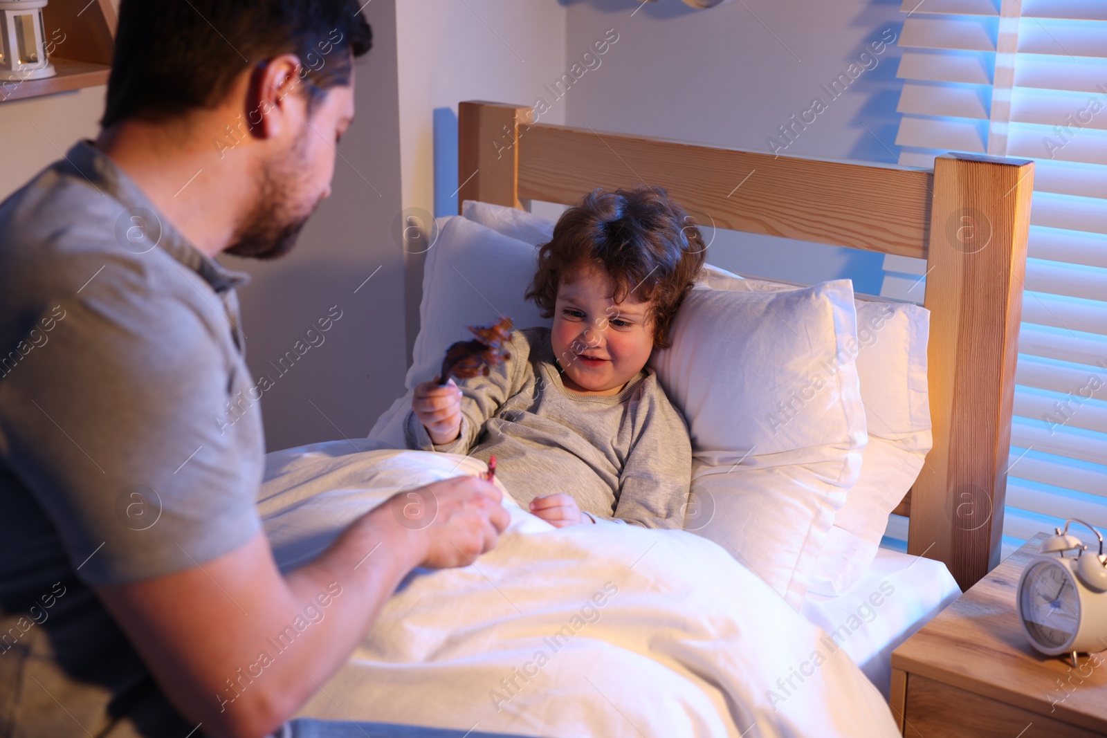 Father playing with his son before bedtime in bedroom, selective focus Photo of Father playing with his son before bedtime in bedroom, selective focus