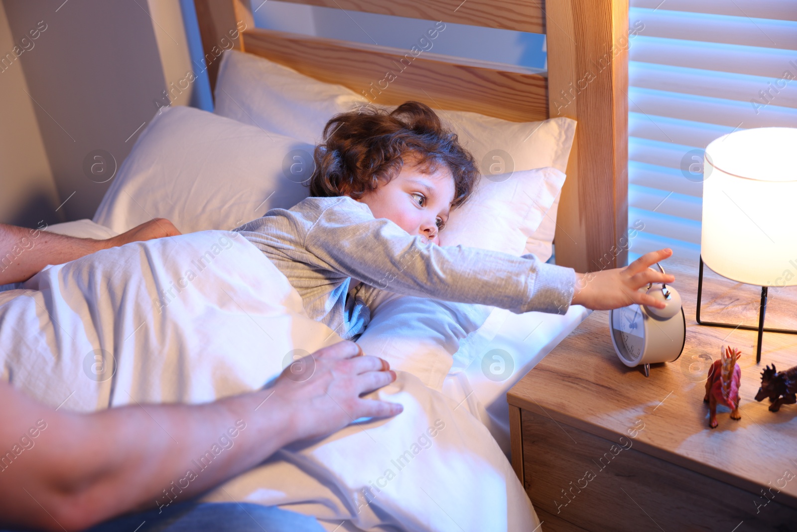 Father putting his little son to sleep at home, closeup. Bedtime Photo of Father putting his little son to sleep at home, closeup. Bedtime