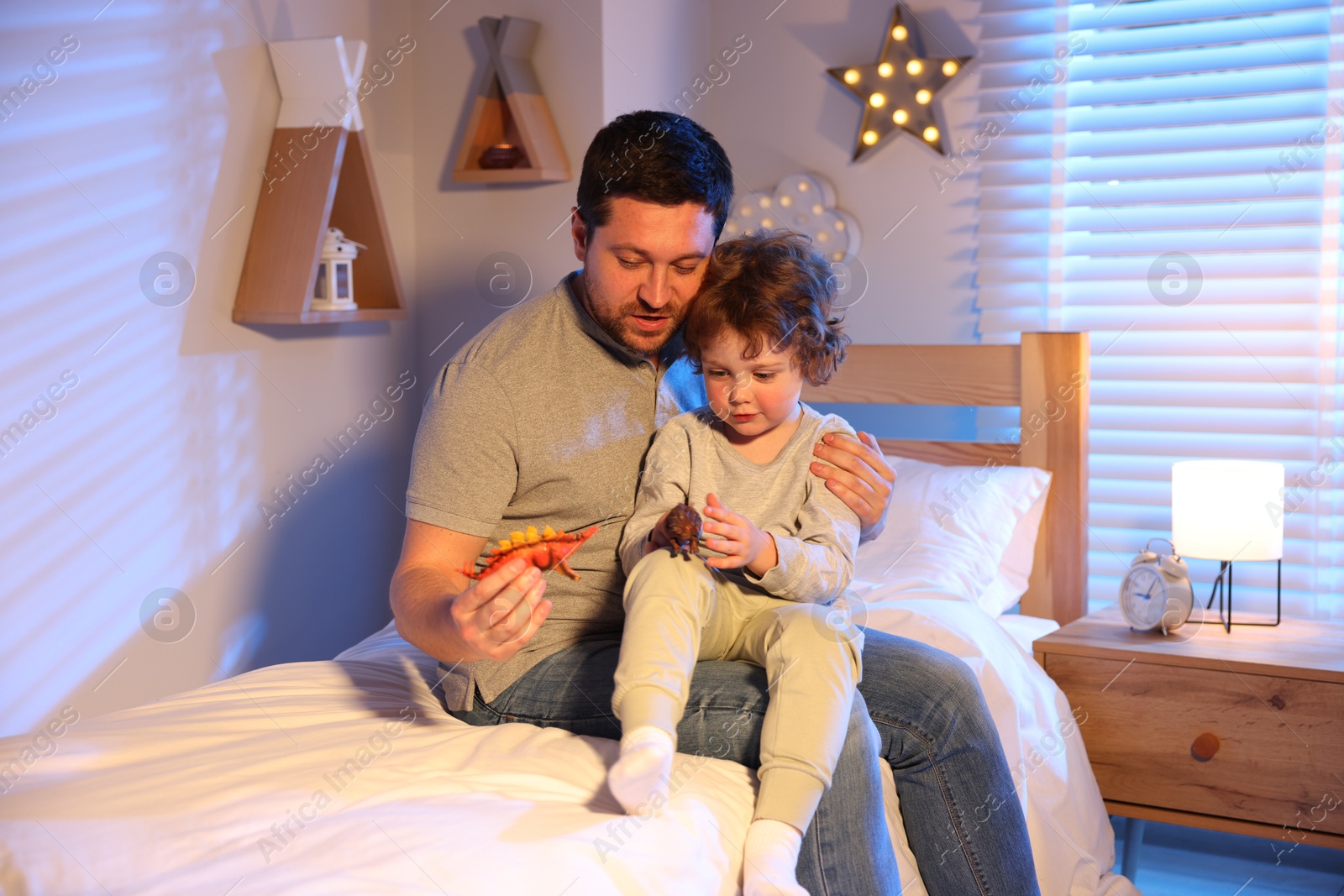 Father playing with his son before bedtime on bed at home Photo of Father playing with his son before bedtime on bed at home