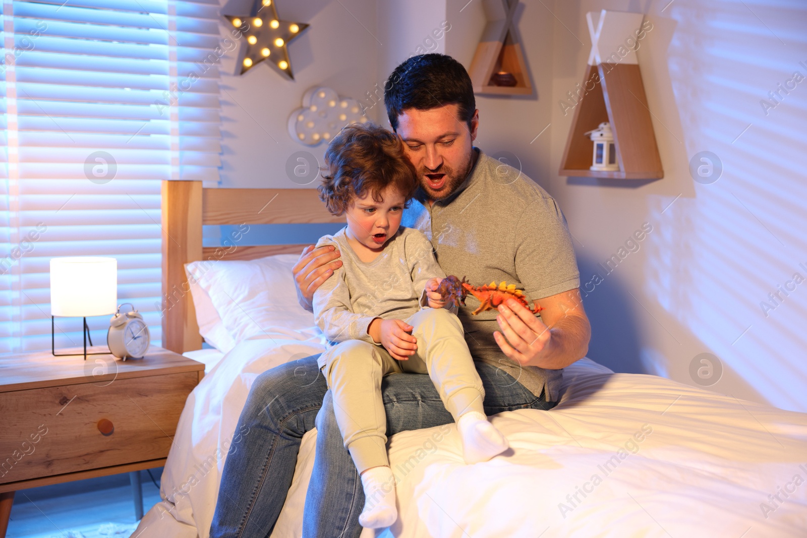 Father playing with his son before bedtime on bed at home Photo of Father playing with his son before bedtime on bed at home
