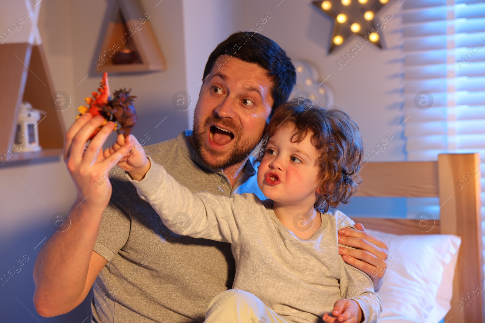 Father playing with his son before bedtime on bed at home Photo of Father playing with his son before bedtime on bed at home