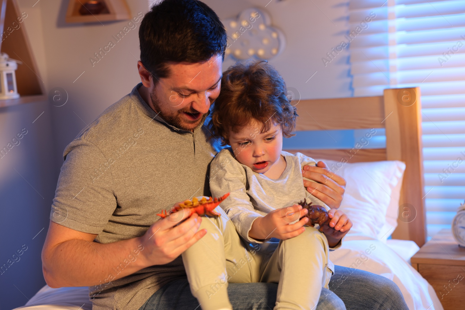 Father playing with his son before bedtime on bed at home Photo of Father playing with his son before bedtime on bed at home