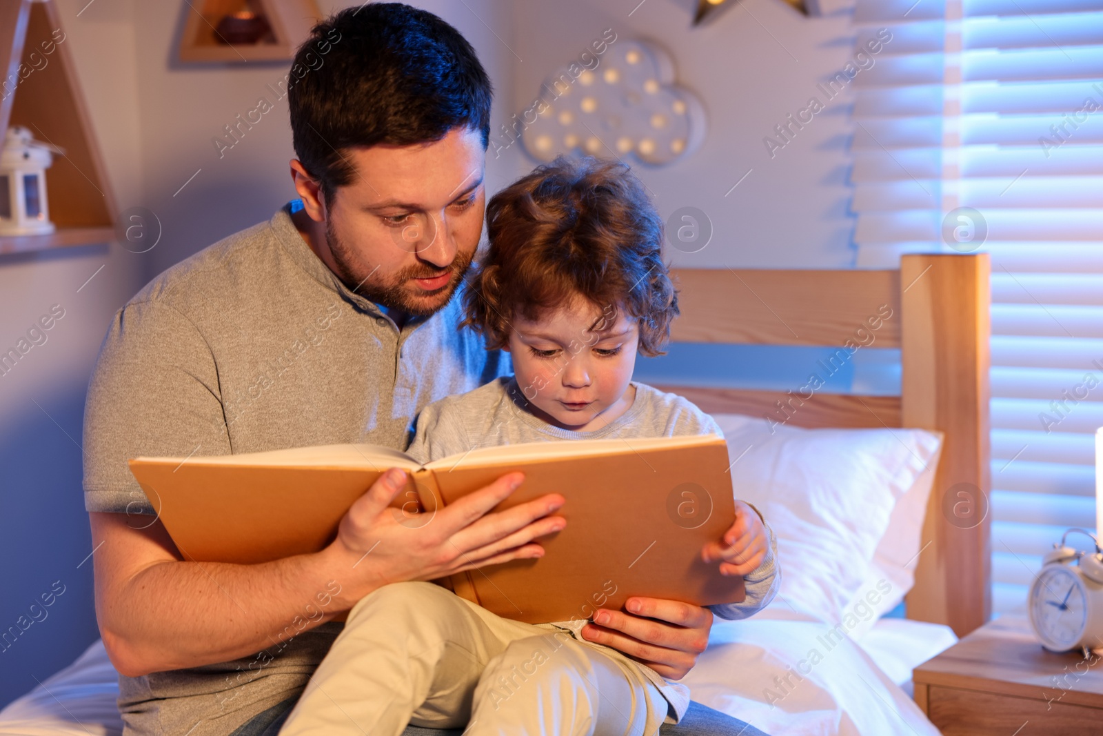 Father reading bedtime story to his son at home Photo of Father reading bedtime story to his son at home