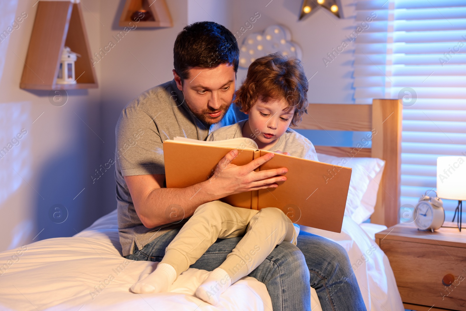 Father reading bedtime story to his son at home Photo of Father reading bedtime story to his son at home