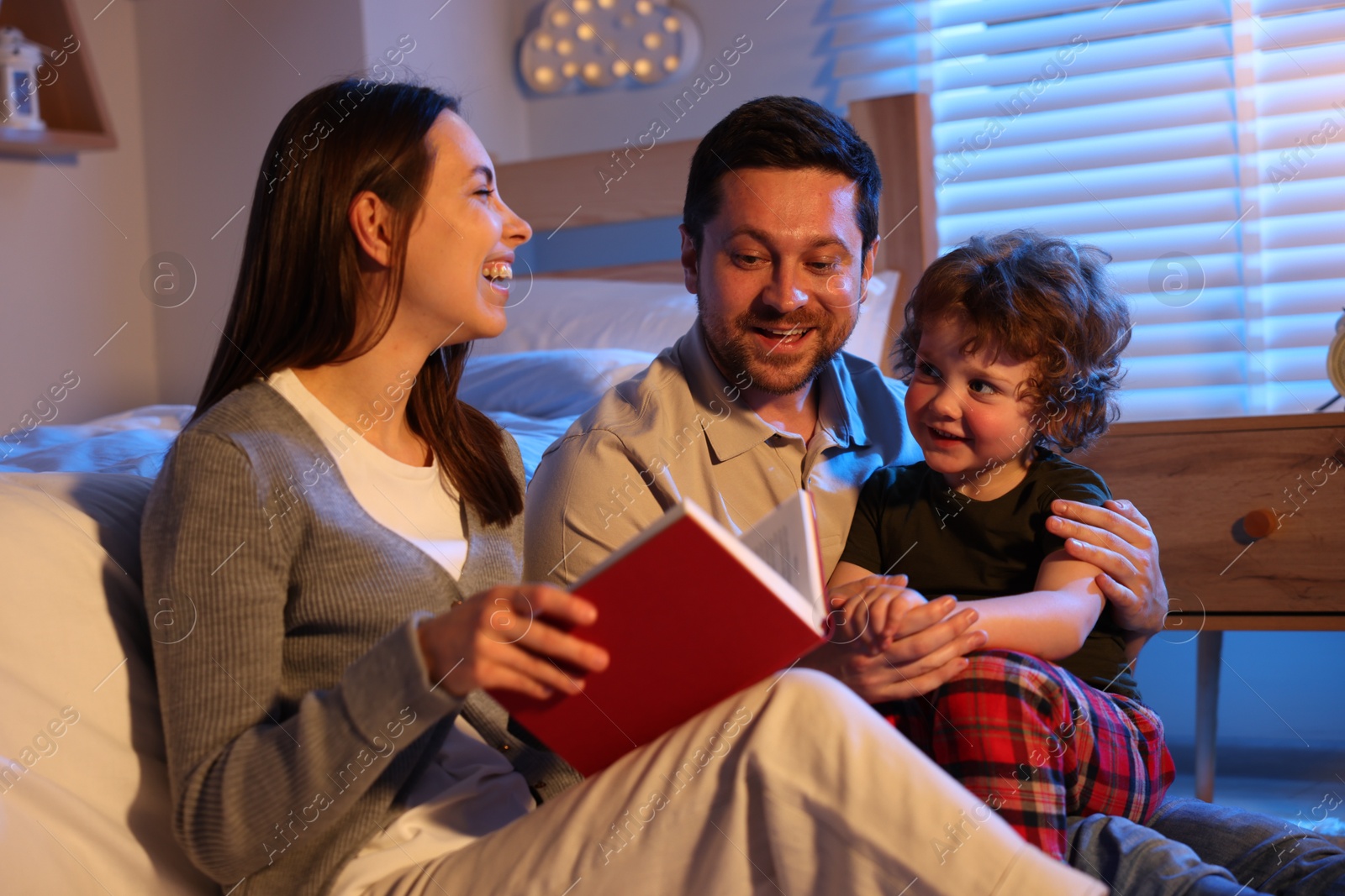 Happy family reading bedtime story at home Photo of Happy family reading bedtime story at home
