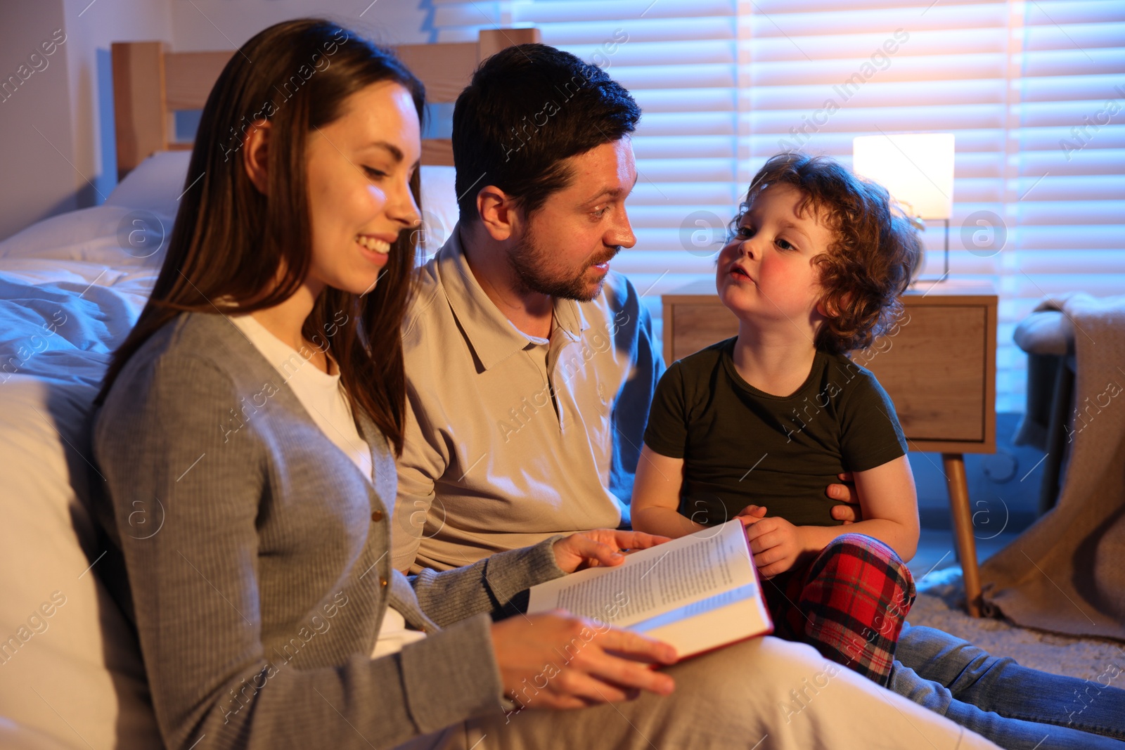 Happy family reading bedtime story at home Photo of Happy family reading bedtime story at home