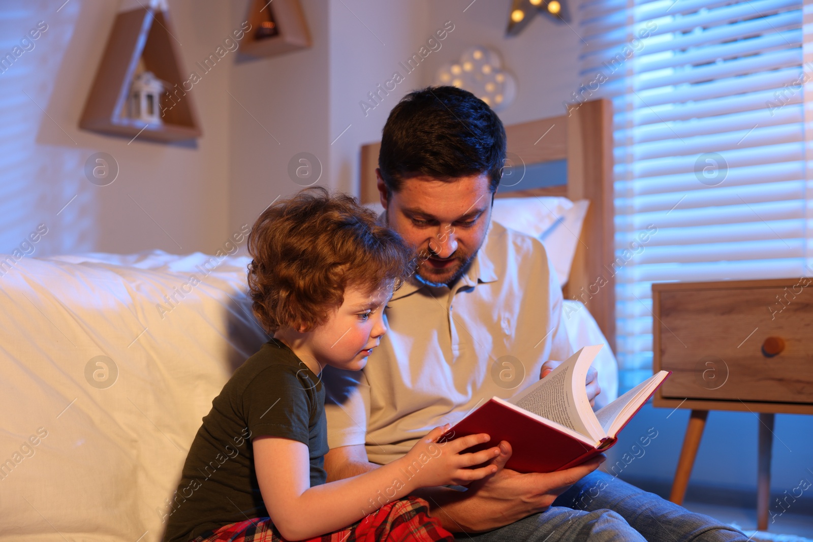Father reading bedtime story to his son at home Photo of Father reading bedtime story to his son at home