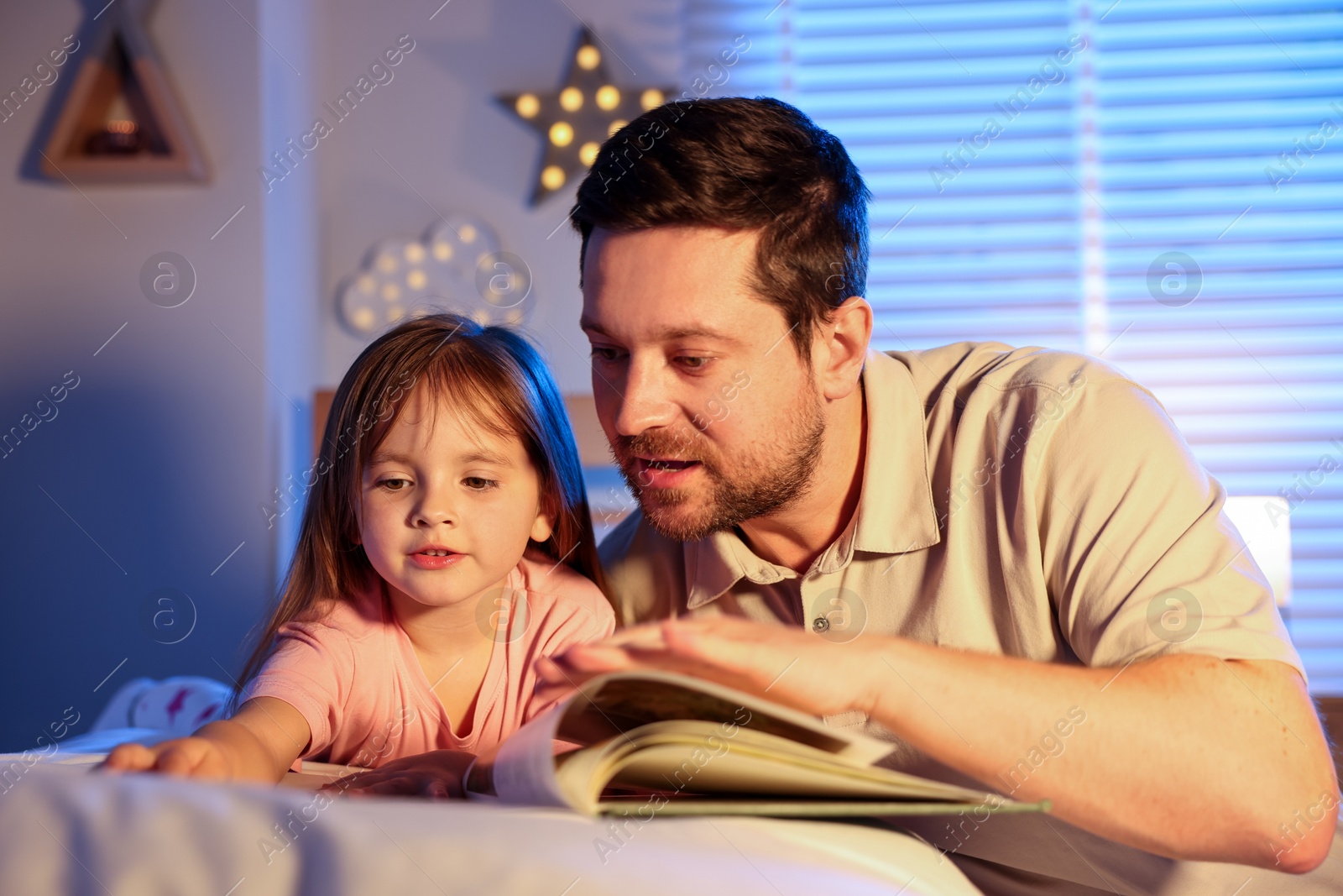 Father reading bedtime story to her daughter at home Photo of Father reading bedtime story to her daughter at home