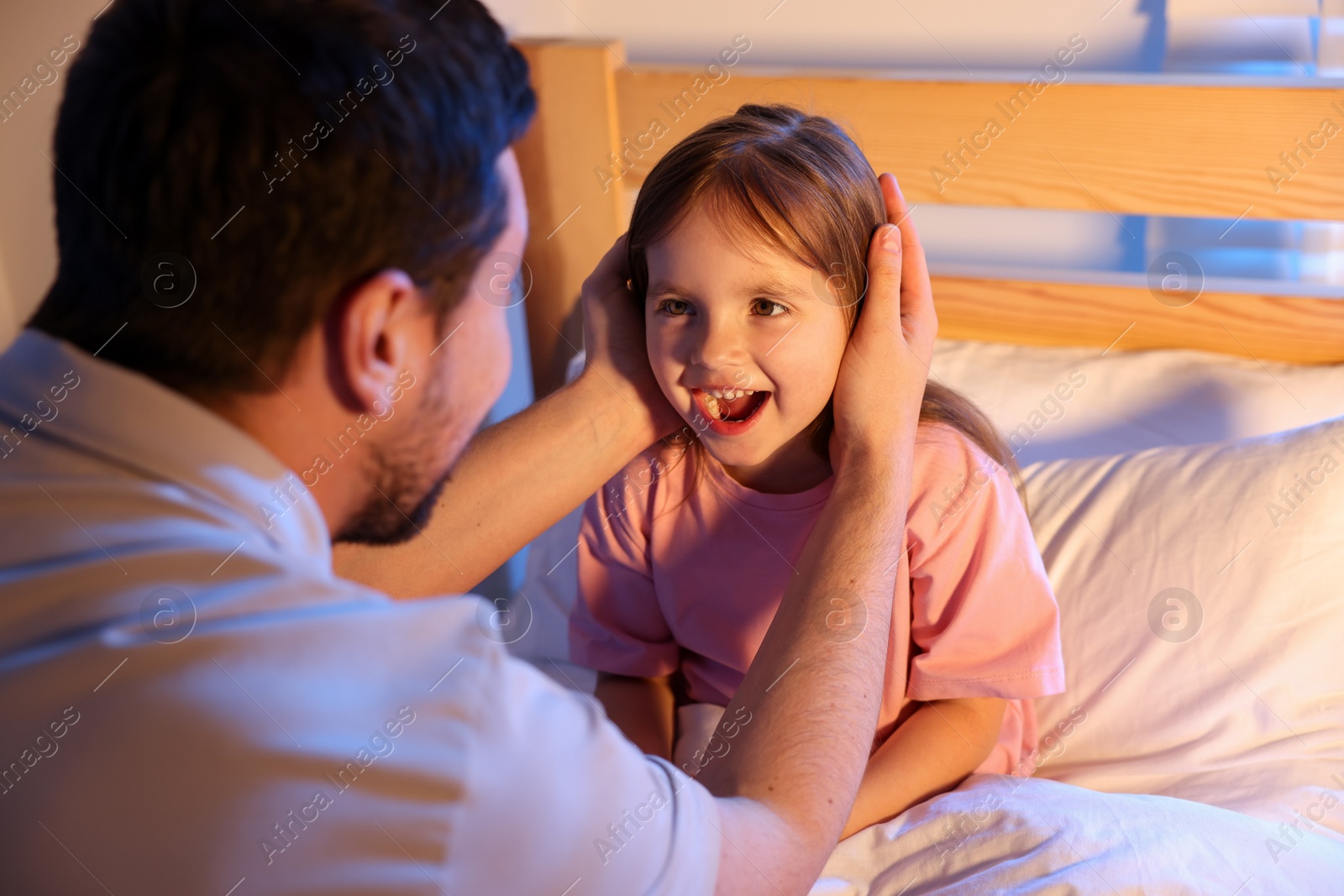 Father and his daughter having fun before bedtime in bedroom Photo of Father and his daughter having fun before bedtime in bedroom