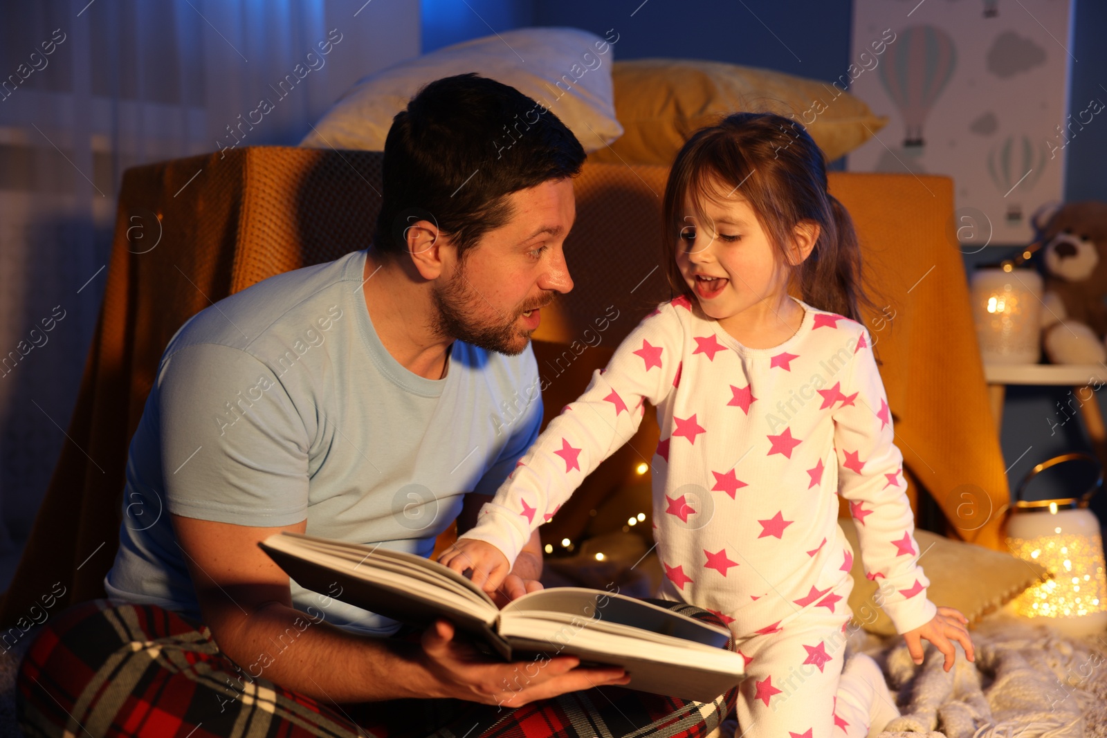 Father reading bedtime story to his daughter at home Photo of Father reading bedtime story to his daughter at home