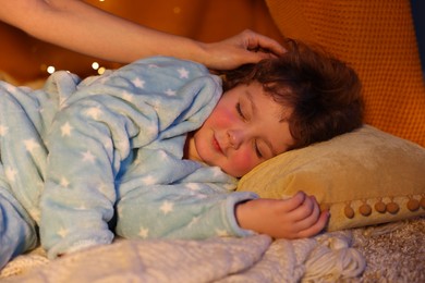 Photo of Mother putting her little son to sleep at home, closeup. Bedtime