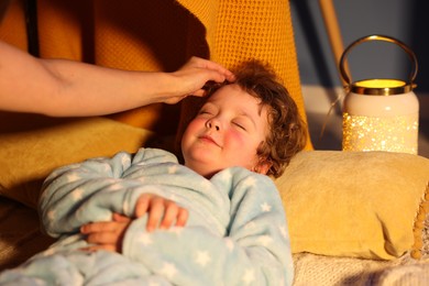 Photo of Mother putting her little son to sleep at home, closeup. Bedtime