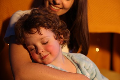 Photo of Happy mother and her sleepy son at home, closeup. Bedtime