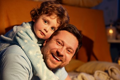 Photo of Family portrait of happy father and his little son at home. Bedtime