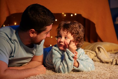 Photo of Father and his son before bedtime on floor at home