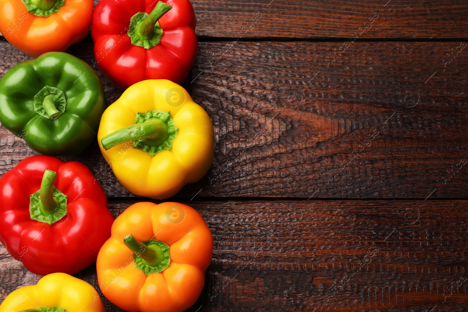 Fresh colorful bell peppers on wooden table, flat lay. Space for text Photo of Fresh colorful bell peppers on wooden table, flat lay. Space for text