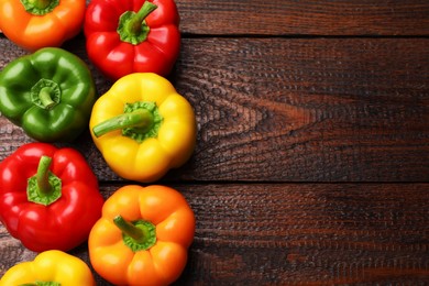 Photo of Fresh colorful bell peppers on wooden table, flat lay. Space for text