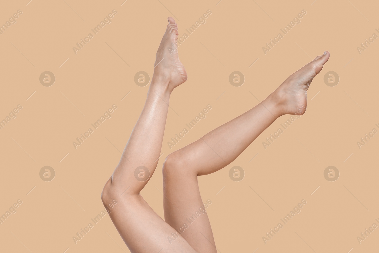 Woman with beautiful smooth legs after epilation on beige background, closeup Photo of Woman with beautiful smooth legs after epilation on beige background, closeup