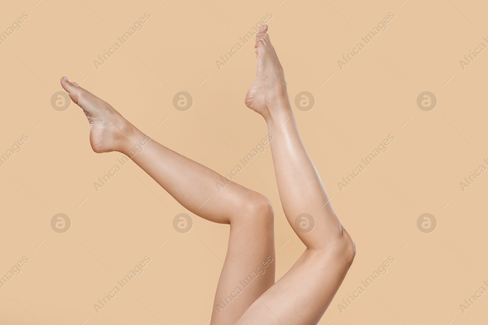 Woman with beautiful smooth legs after epilation on beige background, closeup Photo of Woman with beautiful smooth legs after epilation on beige background, closeup