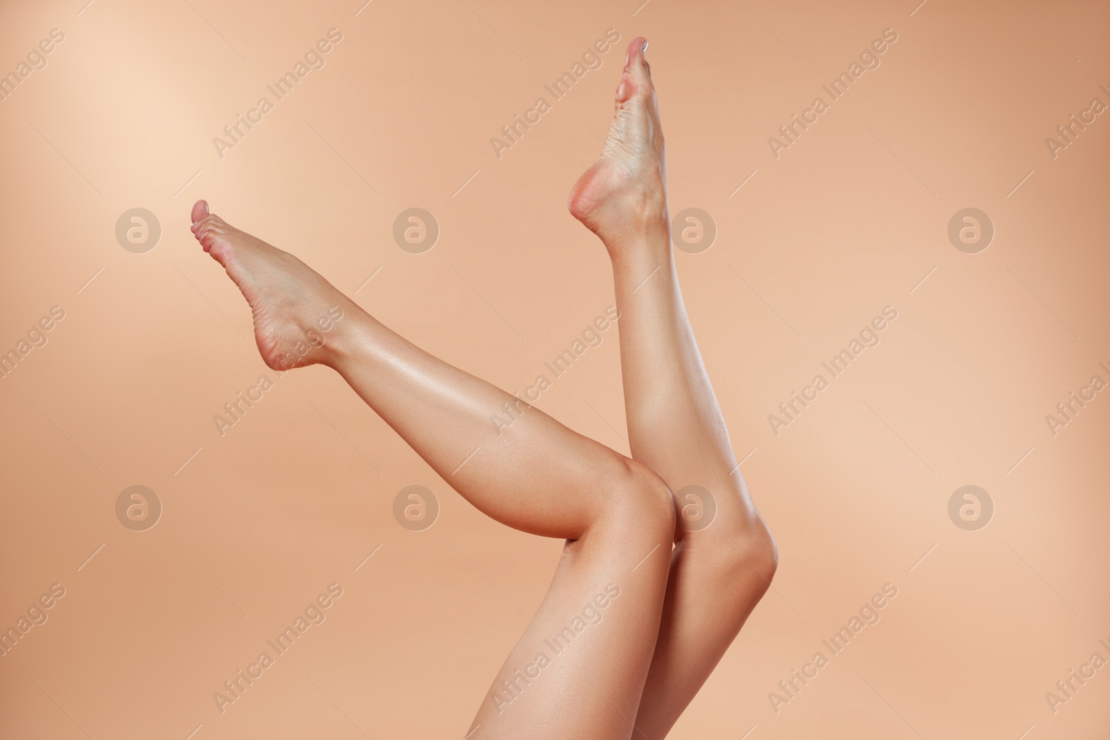 Woman with beautiful smooth legs after epilation on beige background, closeup Photo of Woman with beautiful smooth legs after epilation on beige background, closeup