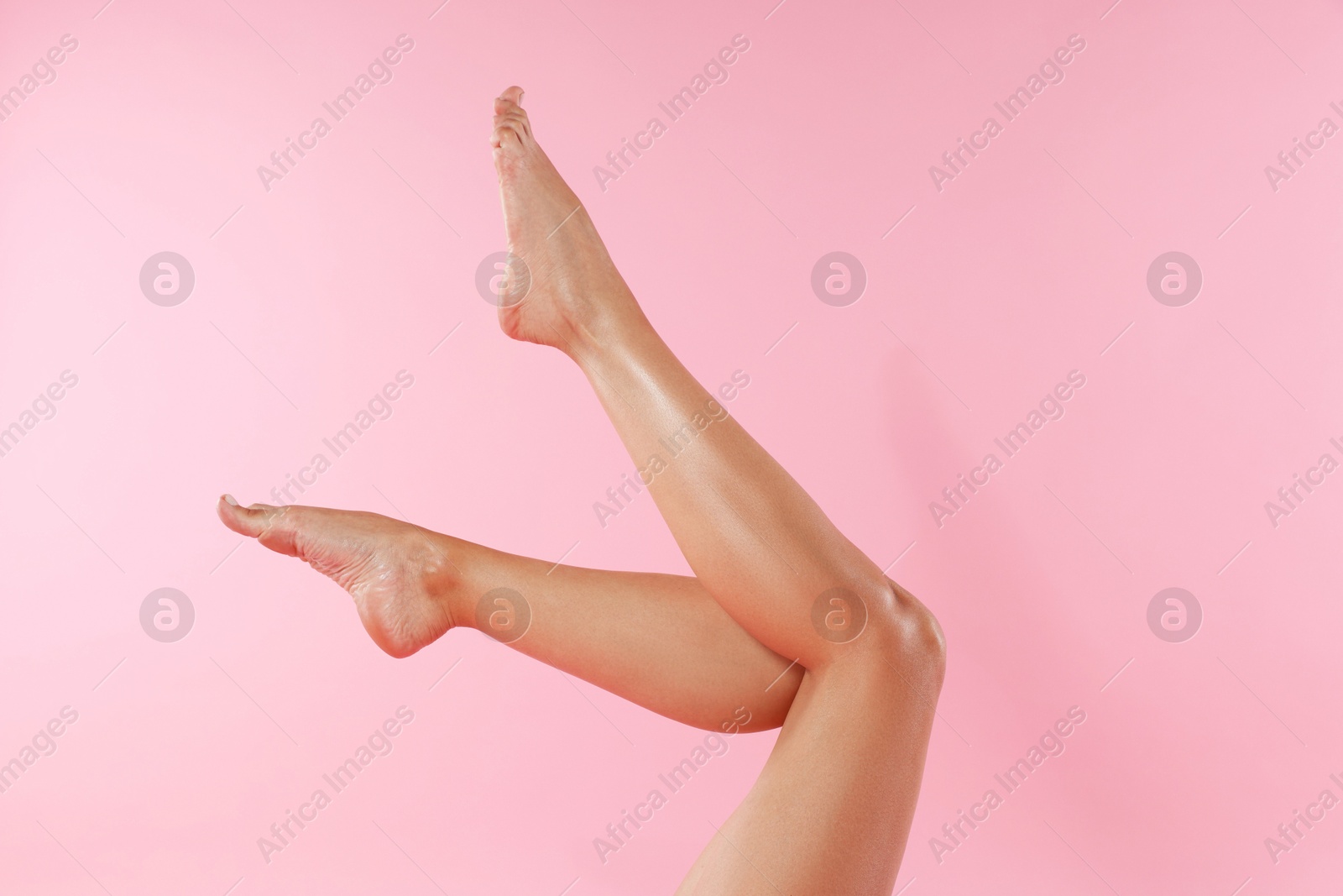 Photo of Woman with beautiful smooth legs after epilation on pink background, closeup