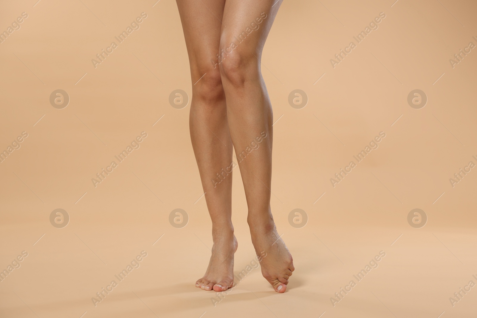 Woman with beautiful smooth legs after epilation on beige background, closeup Photo of Woman with beautiful smooth legs after epilation on beige background, closeup
