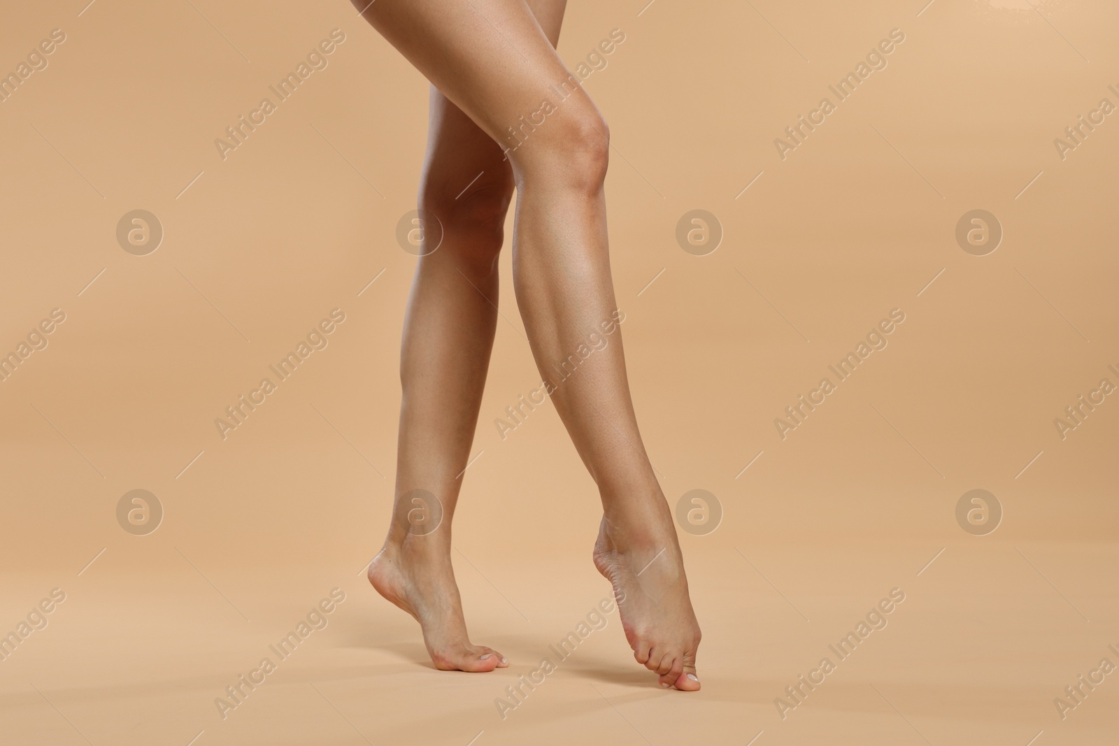 Woman with beautiful smooth legs after epilation on beige background, closeup Photo of Woman with beautiful smooth legs after epilation on beige background, closeup