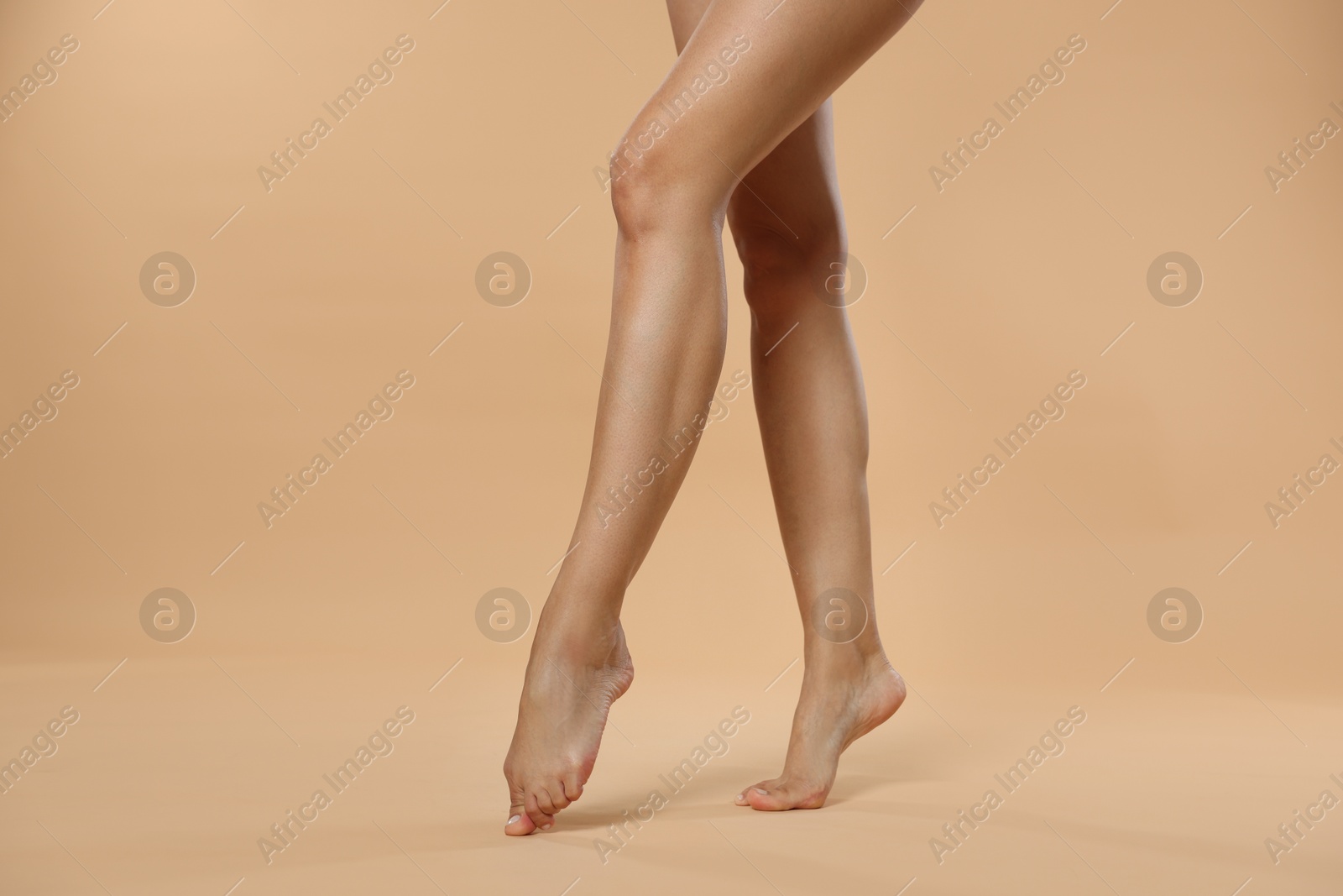 Woman with beautiful smooth legs after epilation on beige background, closeup Photo of Woman with beautiful smooth legs after epilation on beige background, closeup