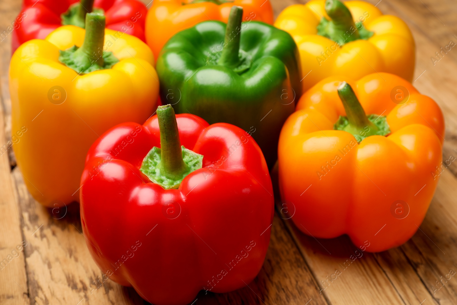 Fresh colorful bell peppers on wooden table, closeup Photo of Fresh colorful bell peppers on wooden table, closeup